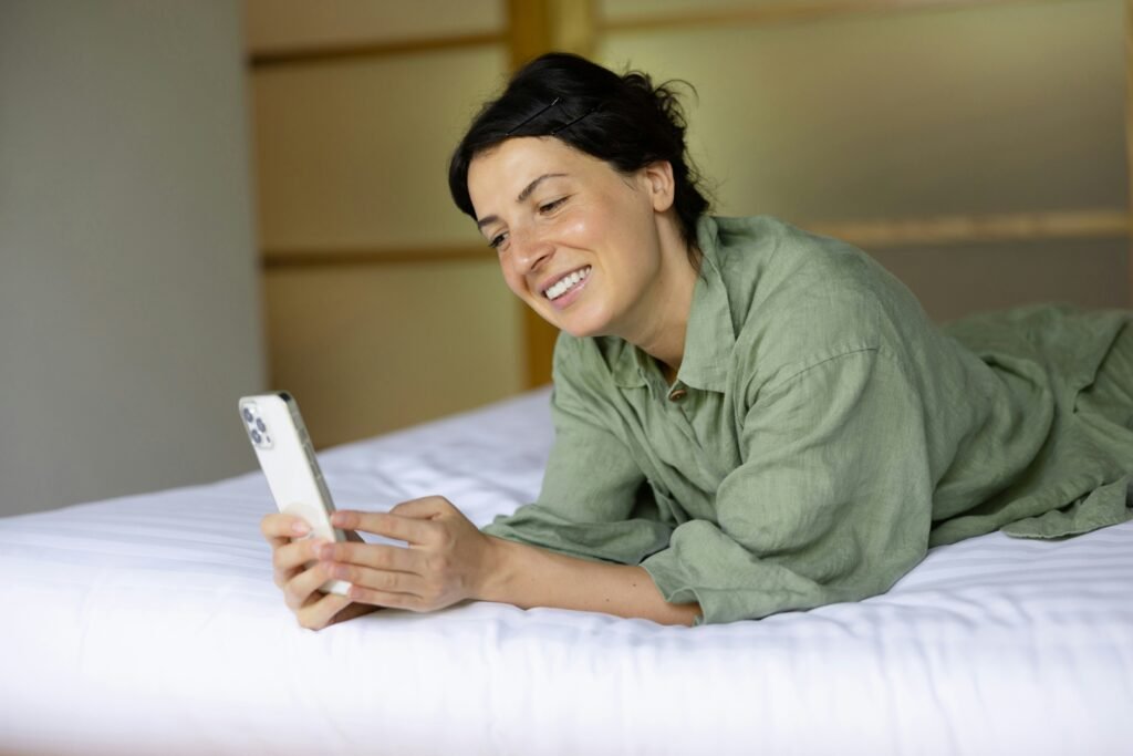 Smiling partner sending a seductive text message to build anticipation.